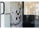 Close-up of a shower with black fixtures, sleek shower panel, and luxurious marble tile at 4031 Oak Forest Cir, Marietta, GA 30062