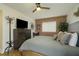 Cozy bedroom with a ceiling fan, brick accent wall, a dresser with a TV, and stylish furnishings at 91 Ne Rumson Ne Rd # B20, Atlanta, GA 30305