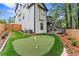 Landscaped backyard features an artificial turf putting green, deck, and wooden fence at 2015 Chelton Se Way, Smyrna, GA 30080
