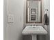 Bathroom featuring a pedestal sink, decorative mirror and modern fixtures at 2015 Chelton Se Way, Smyrna, GA 30080