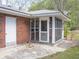View of a brick home with a screened-in porch and adjoining concrete patio at 130 Scarlet Dr, Jonesboro, GA 30236