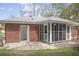 Exterior shot of brick home featuring a screened in porch and concrete patio at 130 Scarlet Dr, Jonesboro, GA 30236