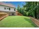 Large, grassy backyard with fencing and a view of the home's exterior and deck at 244 Cedar Ridge Way, Dallas, GA 30157