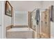 Modern bathroom with glass shower and soaking tub with neutral tile and many windows for natural light at 244 Cedar Ridge Way, Dallas, GA 30157