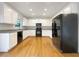 A well lit and modern kitchen features all white cabinetry, hardwood floors, and stainless steel appliances at 3110 Cambrian Ter, Austell, GA 30106