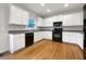 Modern kitchen featuring white cabinets, black appliances and hardwood floors at 3110 Cambrian Ter, Austell, GA 30106