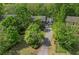 Aerial view of home with a driveway, mature trees, and a well-maintained lawn at 1550 Pine Creek Way, Woodstock, GA 30188