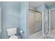 A serene bathroom featuring blue walls and a shower with a gold-trimmed sliding door at 1550 Pine Creek Way, Woodstock, GA 30188