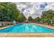 Large community pool with lounge chairs and a lifeguard stand on a sunny day at 1550 Pine Creek Way, Woodstock, GA 30188