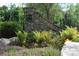 Stone community sign with lush landscaping and colorful flowers adding charm at 1550 Pine Creek Way, Woodstock, GA 30188