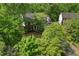 Exterior view of brick home with a dark roof nestled among green trees at 1550 Pine Creek Way, Woodstock, GA 30188