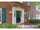 Close-up of the home's elegant green front door with decorative sidelights and brick facade at 1550 Pine Creek Way, Woodstock, GA 30188