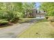 Charming brick home featuring a long driveway and a manicured lawn at 1550 Pine Creek Way, Woodstock, GA 30188