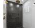 Modern shower featuring black honeycomb tile, gold fixtures, and a convenient recessed niche at 2870 Ridgemore Nw Rd, Atlanta, GA 30318