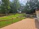 A multi-level deck overlooks a beautifully landscaped backyard with lush lawn, a rock garden, and mature trees at 1960 Calvin Dr, Duluth, GA 30097