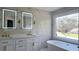 Bathroom with dual vanity, large soaking tub, and windows looking out to wooded yard at 1960 Calvin Dr, Duluth, GA 30097