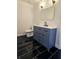 Elegant bathroom featuring black marble floors, a blue vanity, and modern gold fixtures at 1960 Calvin Dr, Duluth, GA 30097