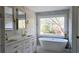 Bright bathroom with double vanity, soaking tub and large window overlooking backyard at 1960 Calvin Dr, Duluth, GA 30097