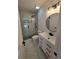 Modern bathroom with marble tiled shower, white vanity, and a round backlit mirror at 1960 Calvin Dr, Duluth, GA 30097
