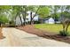 Scenic home view nestled among mature trees, with an expansive lawn and long driveway at 1960 Calvin Dr, Duluth, GA 30097