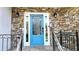 Stylish blue front door with leaded glass detail, flanked by stone accents and classic sconces at 1960 Calvin Dr, Duluth, GA 30097