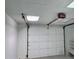 Bright garage featuring a white paneled garage door and ceiling with fluorescent lights at 1960 Calvin Dr, Duluth, GA 30097