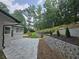 Beautiful backyard patio with stone retaining wall and lush landscaping, creating a private outdoor space at 1960 Calvin Dr, Duluth, GA 30097