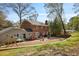 Brick home with a large backyard featuring patio furniture, a playground, and a grassy lawn at 7130 Spalding Ne Ct, Atlanta, GA 30328