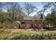 Brick home with a large backyard featuring patio furniture, a playground, and a grassy lawn at 7130 Spalding Ne Ct, Atlanta, GA 30328