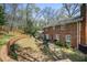 Backyard showing brick house, patio with furniture, and landscaped lawn with a playground at 7130 Spalding Ne Ct, Atlanta, GA 30328