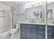 Renovated bathroom featuring a blue vanity with a marble countertop and framed mirror at 7130 Spalding Ne Ct, Atlanta, GA 30328