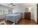 Comfortable bedroom with hardwood floors, ceiling fan, and a closet for ample storage at 7130 Spalding Ne Ct, Atlanta, GA 30328