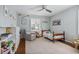 Well-lit bedroom featuring hardwood floors, ceiling fan, and a window with plantation shutters at 7130 Spalding Ne Ct, Atlanta, GA 30328
