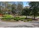 Well-manicured front yard featuring green shrubs and mature trees on a corner lot at 7130 Spalding Ne Ct, Atlanta, GA 30328