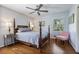 Cozy bedroom with hardwood floors, ceiling fan, and a well-lit seating nook at 7130 Spalding Ne Ct, Atlanta, GA 30328