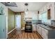 Bright kitchen with white cabinets, wood floors, a mosaic backsplash, and modern lighting at 1239 Avonwood Sw Cir, Atlanta, GA 30311