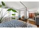 Airy bedroom with canopy bed, hardwood floors, tropical plants, and sheer curtains creates a peaceful oasis at 1903 River Birch Ln, Atlanta, GA 30316