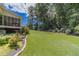 Expansive backyard featuring lush lawn, landscaped garden beds, and a screened-in porch area at 4481 Lucerne Sw Pl, Lilburn, GA 30047