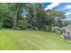 Expansive backyard with lush green lawn, mature trees, and blue sky creating a private outdoor oasis perfect for recreation at 4481 Lucerne Sw Pl, Lilburn, GA 30047
