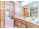 Bathroom with wood cabinets, double sinks, and tiled floor connecting to the bedroom at 4481 Lucerne Sw Pl, Lilburn, GA 30047