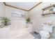 Bathroom features a large tub with jets, white tile surround, and wood trim at 4481 Lucerne Sw Pl, Lilburn, GA 30047