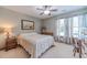 Cozy bedroom with a neutral palette, carpeted floor, ceiling fan, and large windows at 4481 Lucerne Sw Pl, Lilburn, GA 30047