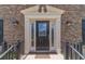Elegant front door with decorative glass and sidelights, framed by black sconces at 4481 Lucerne Sw Pl, Lilburn, GA 30047