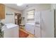 Functional laundry room with washer, dryer, refrigerator, and ample storage space at 4481 Lucerne Sw Pl, Lilburn, GA 30047