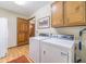 Well-equipped laundry room featuring modern washer and dryer, cabinets, and wood-look flooring at 4481 Lucerne Sw Pl, Lilburn, GA 30047