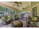 Relaxing screened-in porch with wicker seating, ceiling fans, and green outdoor views, a perfect spot for relaxation and entertainment at 4481 Lucerne Sw Pl, Lilburn, GA 30047