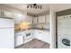 Galley kitchen featuring white appliances, tile backsplash, in-unit laundry, and ample cabinet space at 3987 Bayside Cir, Atlanta, GA 30340