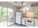 Bright kitchen with white cabinets, stove, refrigerator, tile backsplash, and deck access at 3987 Bayside Cir, Atlanta, GA 30340