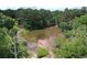 Overhead view of a murky pond surrounded by green, mature trees and other luscious landscaping at 3987 Bayside Cir, Atlanta, GA 30340