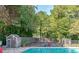 Community pool featuring a tennis court, a small storage shed and is enclosed by a fence at 3987 Bayside Cir, Atlanta, GA 30340
